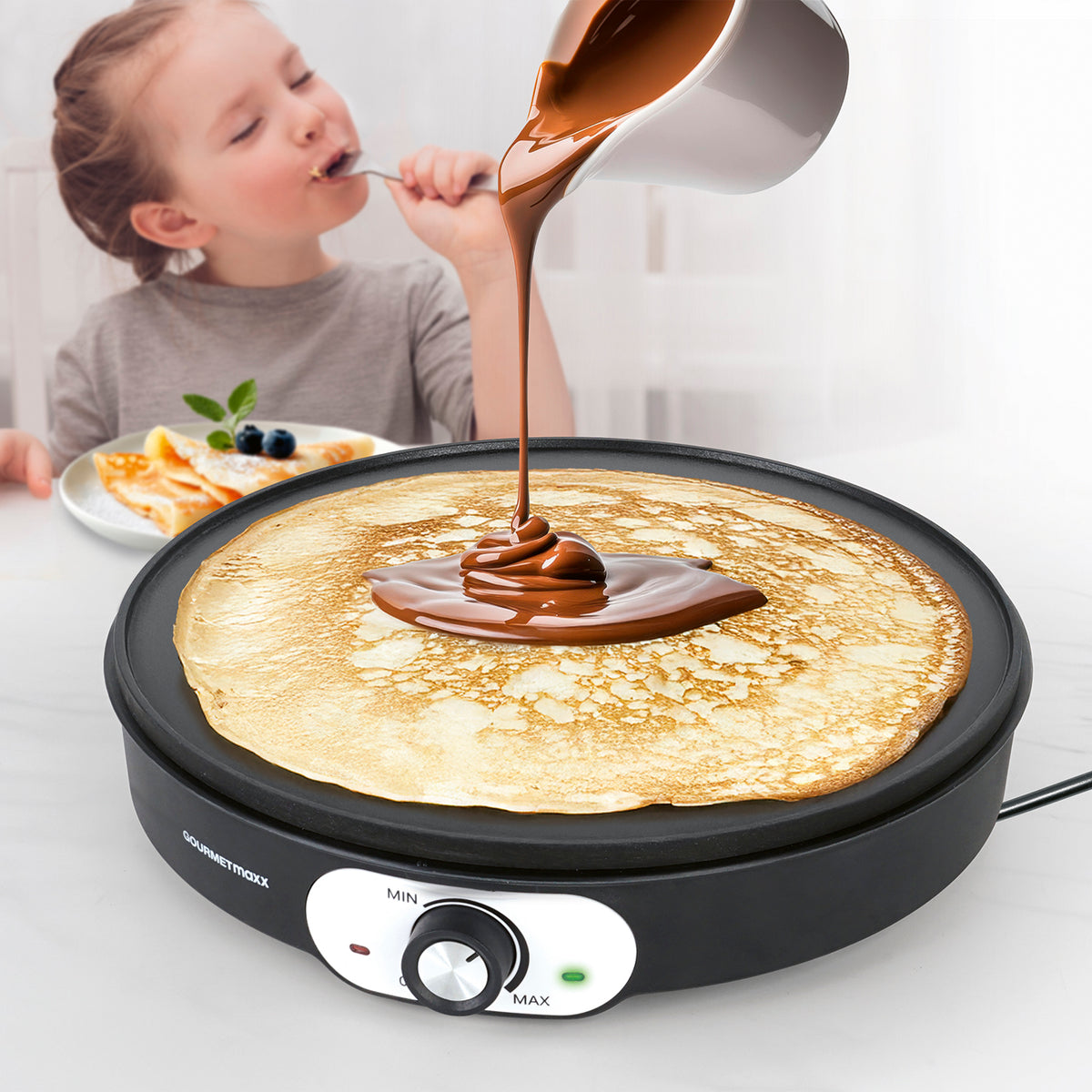 Crêpe Maker mit antihaftbeschichteter Platte beim Zubereiten eines Crêpes mit Schokoladensauce