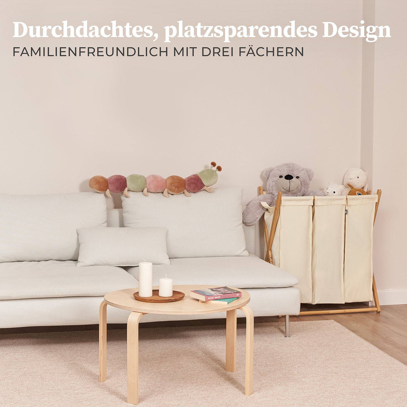 Wäschesammler "Xavier" 150 l - 3 Fächer - Beige in modernem Wohnzimmer mit Sofa und Kuscheltieren neben dem Wäschesammler.