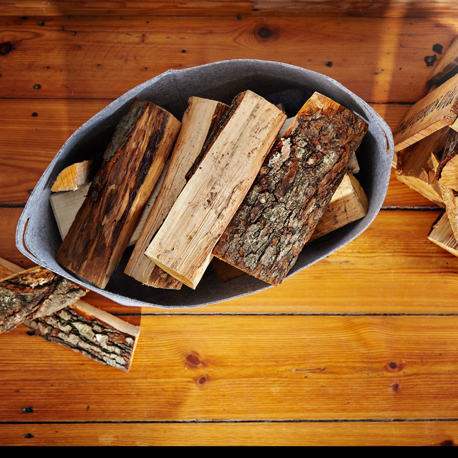 Kaminholztasche aus Filz mit Tragegriff, dunkelgrau, 40 x 25 x 28 cm, gefüllt mit Kaminholz auf Holzfußboden.