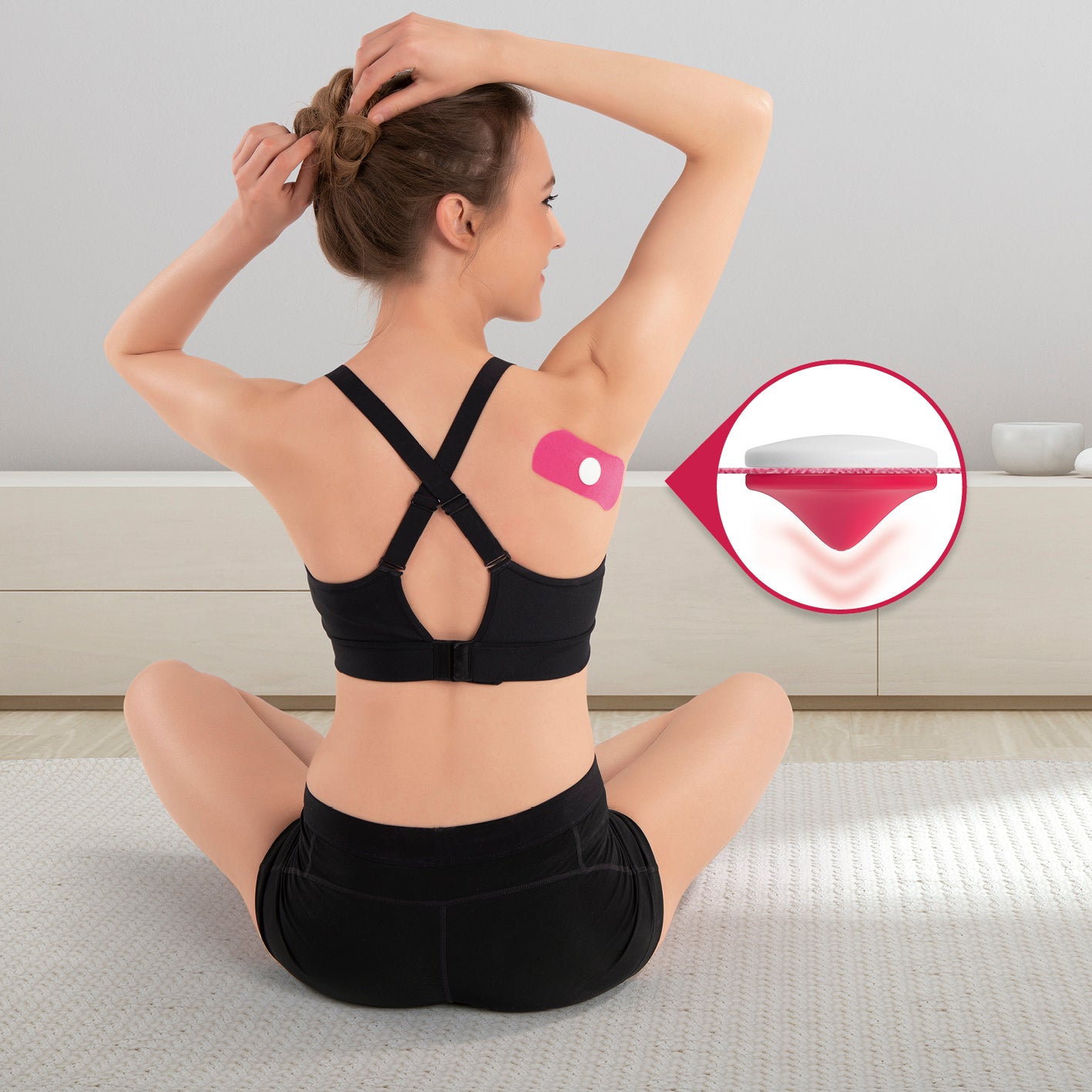 Frau sitzt im Yoga-Positur mit Triggerknopf "Intense" - 3er-Set auf Schulter zur Muskelentspannung und Schmerzlinderung.