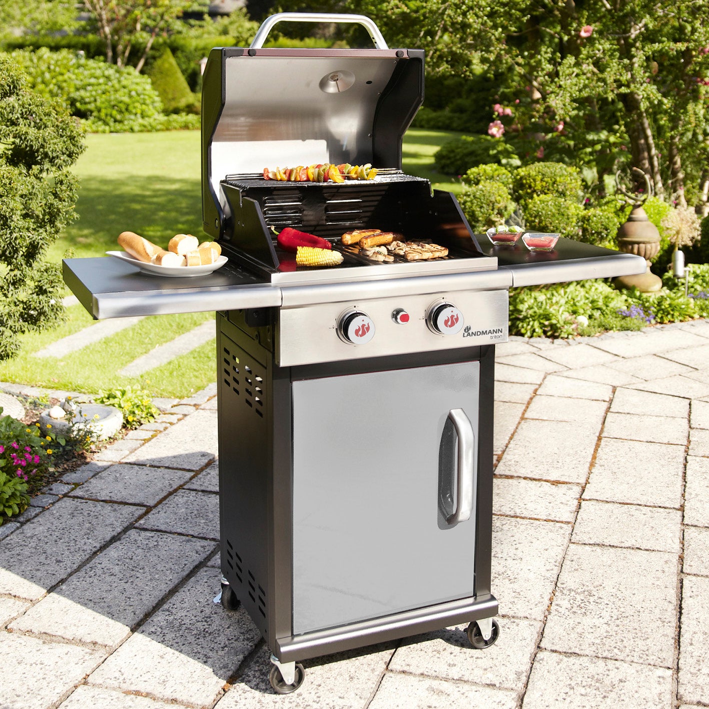 Gasgrill Triton PTS 2.0 - silber mit 2 Edelstahl-Brennern, emailliertem Gusseisenrost und geschlossenem Unterschrank aus Edelstahl.