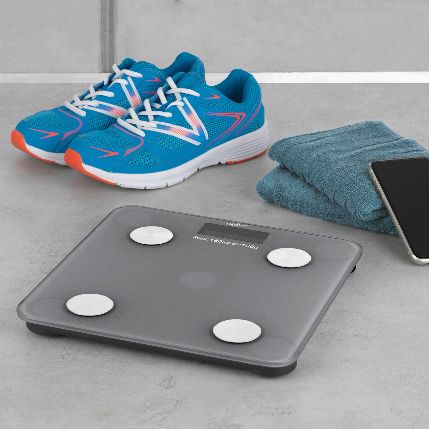 Personen-Waage Körperanalyse mit Bluetooth & App grau neben blauen Sportschuhen, Handtuch und Smartphone auf Boden