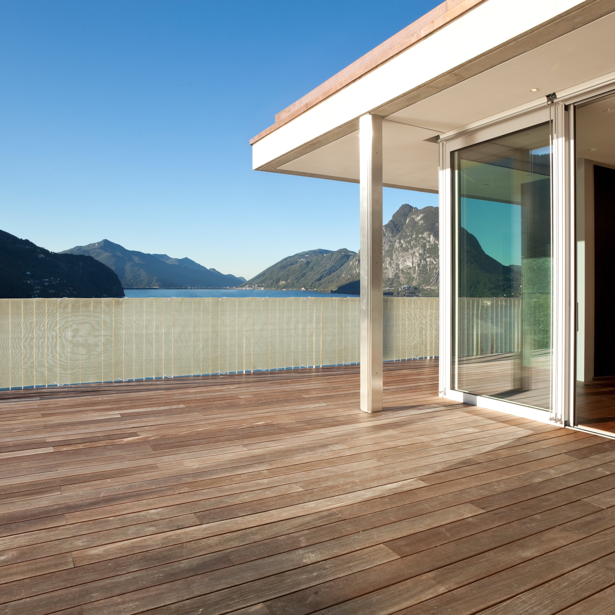 Balkonsichtschutz inkl. Befestigungsseil - 0,9 x 5 m - Sand auf Balkon mit Berg- und Seeblick, aus robustem HDPE-Material mit UV-Schutz.