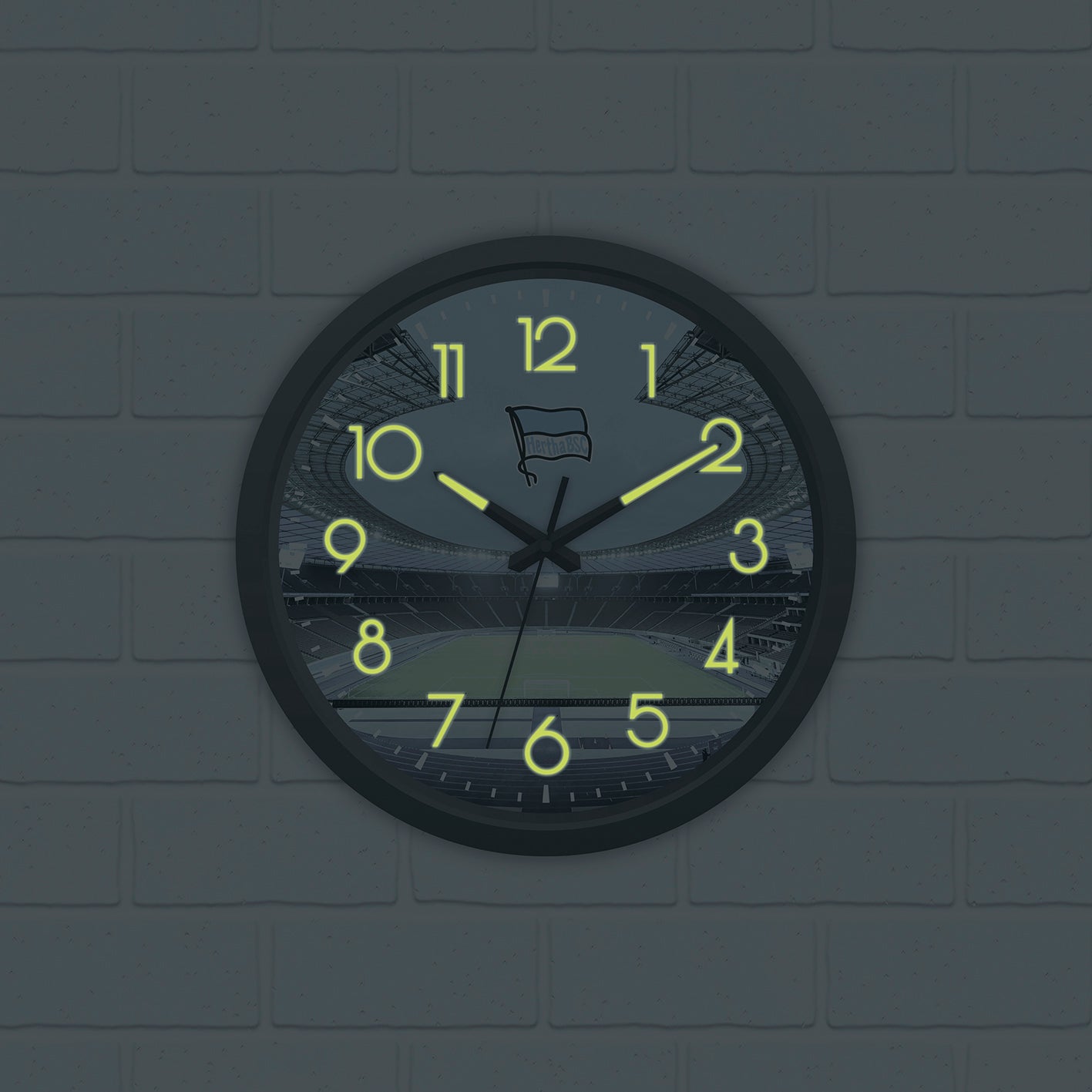 Wanduhr "Glow in the dark" mit Logo, Stadion-Motiv, nachleuchtende Zahlen und Zeiger, batteriebetrieben, gut sichtbar bei Tag und Nacht.
