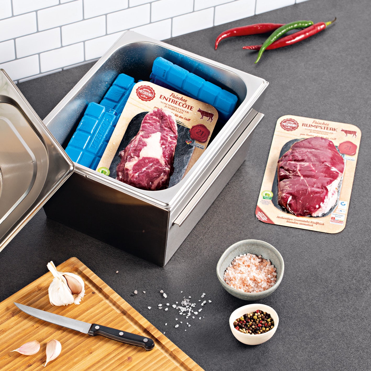 Gasgrill COOL BLACK 5.2 maxX-Zone wird vorbereitet mit frischem Entrecôte und Rumpsteak für vielseitiges Grillen im Garten.