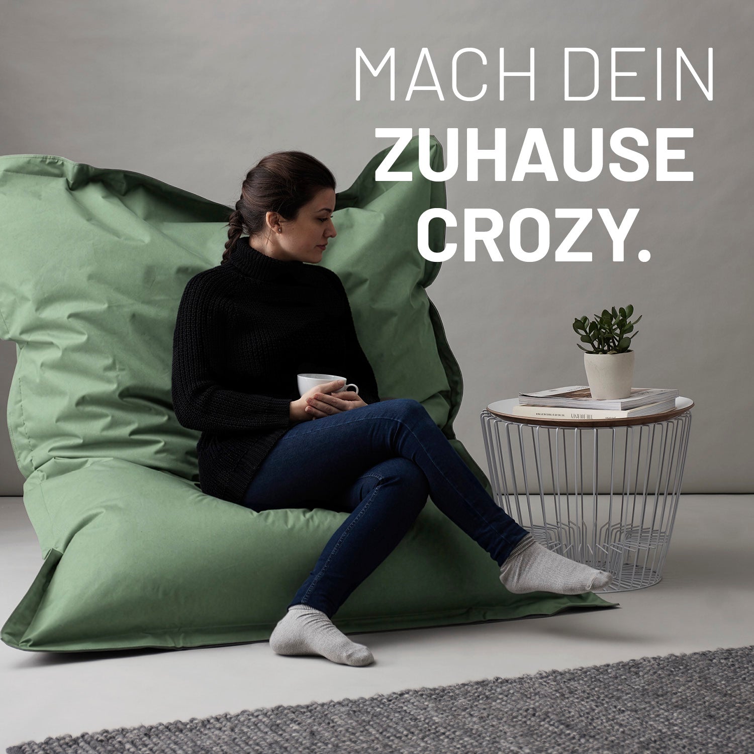 Frau entspannt auf dem Sitzsack Classic XXL (380 L) - indoor & outdoor - Pastell Grün mit bequemer Sitzhaltung und entspannter Atmosphäre.